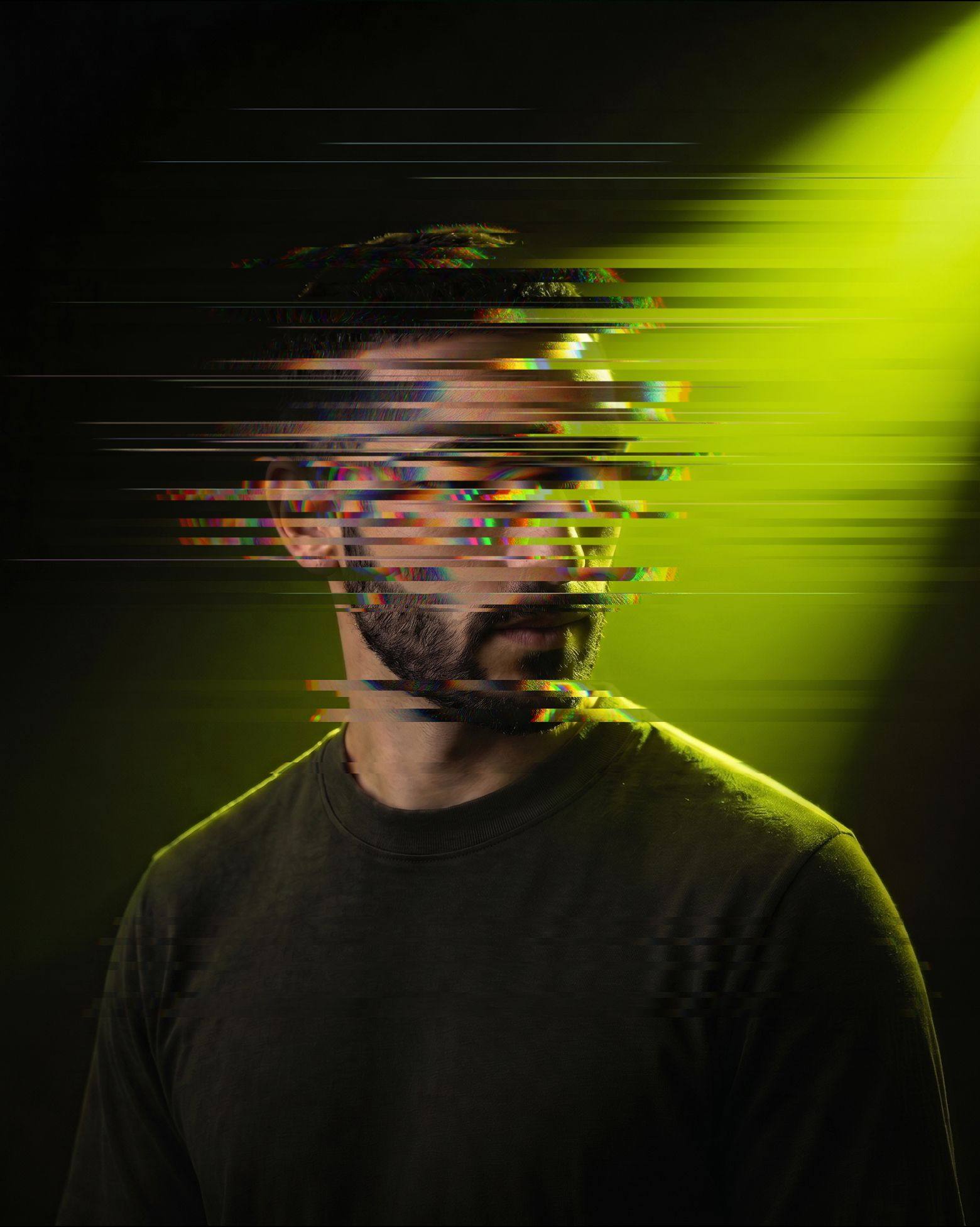 Portrait of a man in a dark suit against a warm grey ground, put through a heavy vertical striation so the face is unreadable: presence without identifying detail.